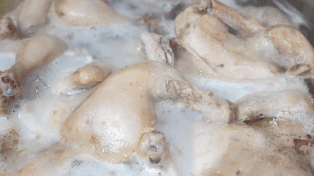 Chicken boiling in a pot with broth