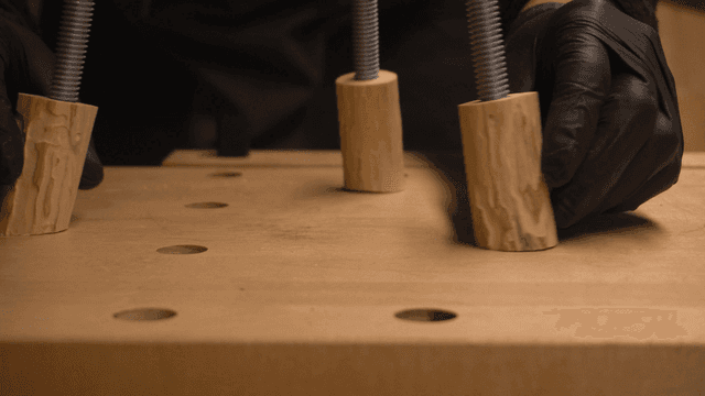 작업대에서 목재 작업물 위치를 조정하는 목수