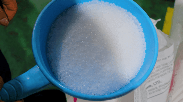 흰색 알갱이로 가득 찬 파란 바가지