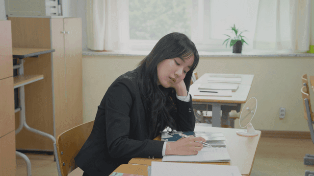 교실에서 공부하다 지루해하는 학생