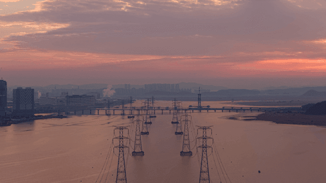 저녁 강 위에 전선이 이어진 송전탑