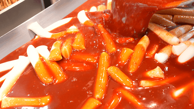 Tteokbokki being cooked in spicy sauce