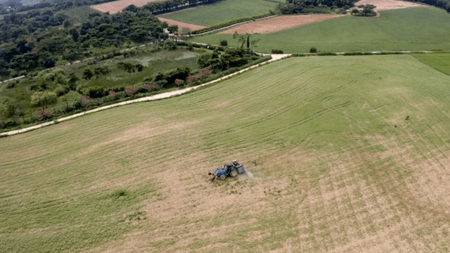 Tractor working on a vast green field