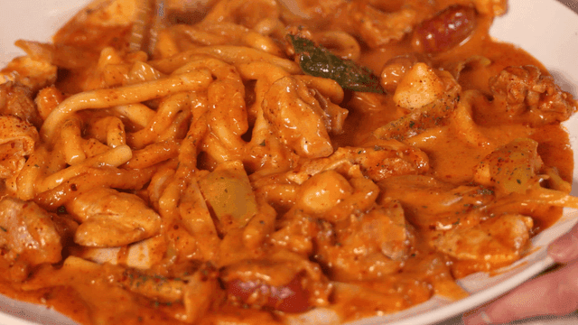 Chopsticks mixing Rosé Jjimdak with spicy chicken and noodles