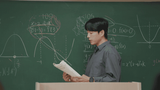 Teacher explaining math on a blackboard