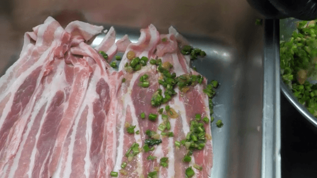 삼겹살 위에 양념을 바르는 손