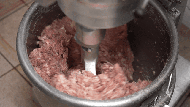 Meat being mixed in a large industrial mixer