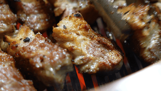 Grilled pork belly sizzling on a grill