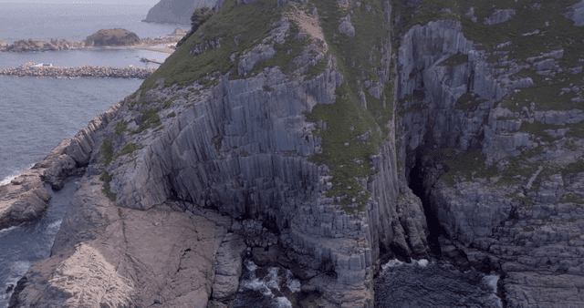 A rugged coastal cliff with ocean waves