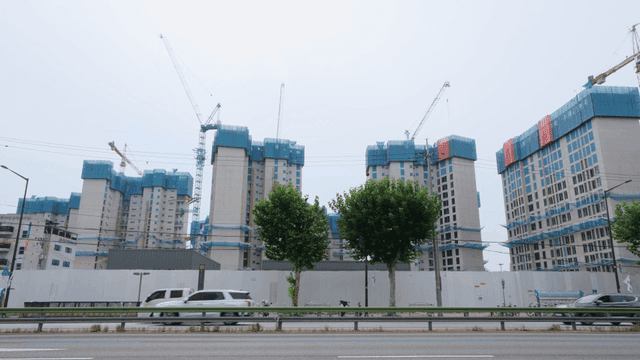 Roadside apartment construction site with crane