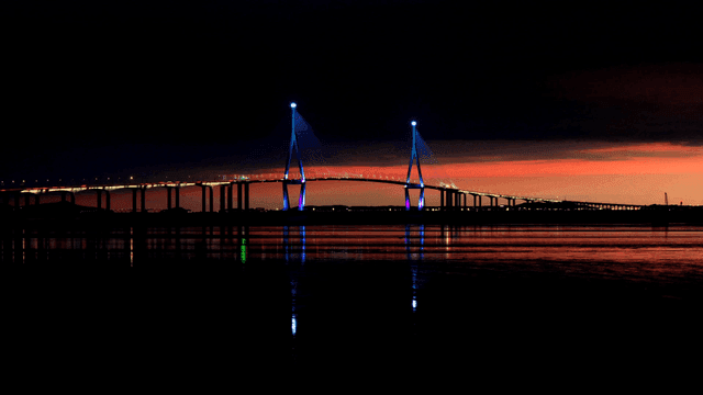 Bridge over calm sea at sunset