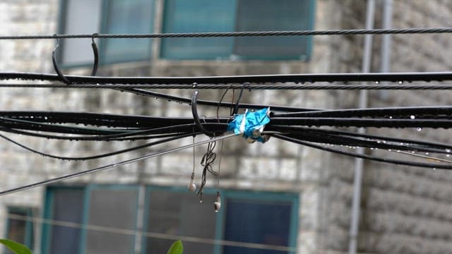 Wet electric cables with tangled earphones on a rainy day