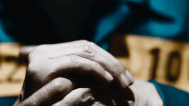 Prisoners holding hands in dark room