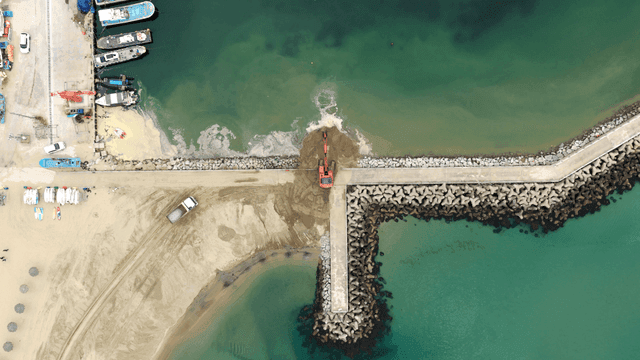 해안 부두에서 작업 중인 굴착기