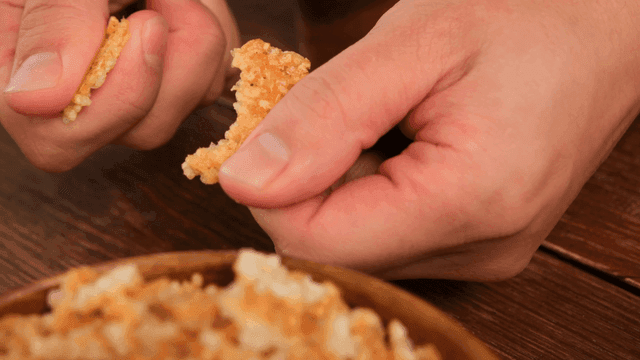 Hands crushing crispy nurungji cookies