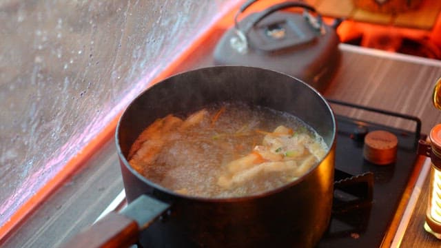 Preparing noodle soup in a cozy indoor setting during a rainy day