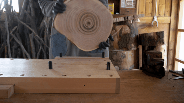 작업장에서 둥근 나무 조각을 들고 있는 목공예 장인