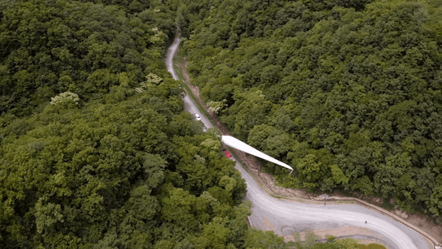 산 속 도로에서 풍력 터빈 자재를 운반하는 모습