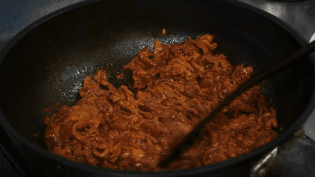 팬에서 매콤한 양념이 된 고기 볶기