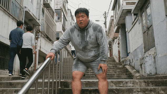 Fat man catching his breath on steep staircase