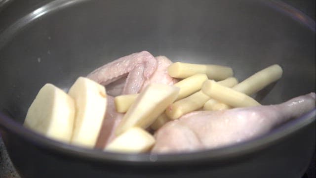 Various ingredients added to pot with chicken