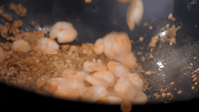 웍에서 다진 마늘과 함께 새우 볶기