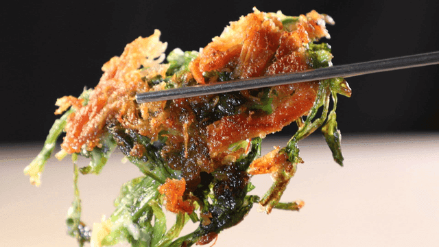 Crispy water parsley chicken pancake picked up with chopsticks