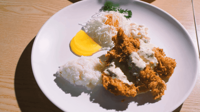 Plate of fish cutlet topped with tartar sauce