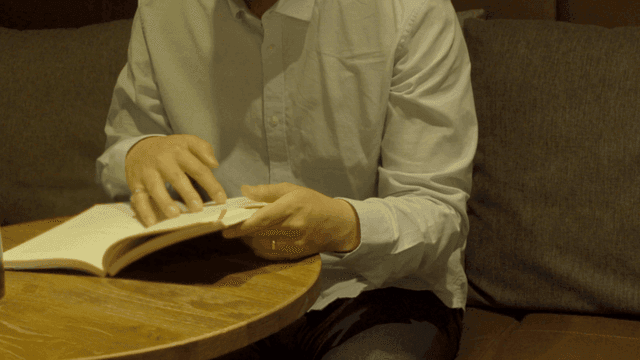 카페 테이블에서 책을 읽는 사람