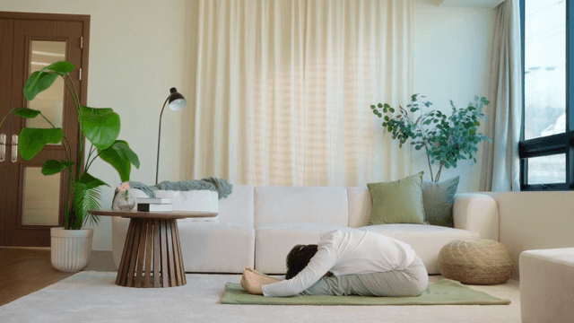 Woman doing yoga in a cozy living room
