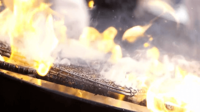 Grilling meat over an open flame