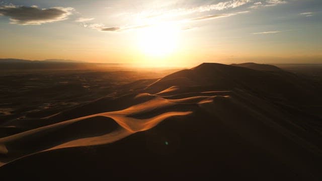 Sunset over vast desert dunes