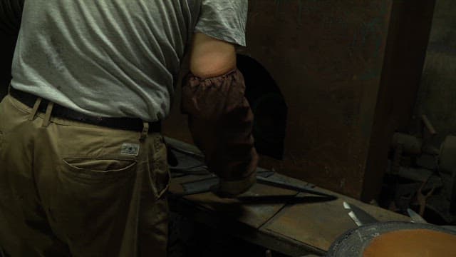 Worker grinding metal with sparks flying