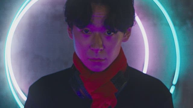 DJ performing a set with neon lights in a dim room