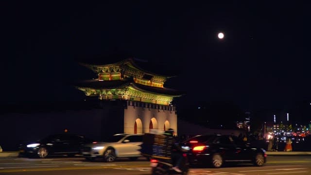 Gyeongbokgung Palace and a crowded road under the moonlit night sky