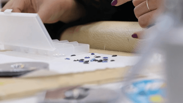 손으로 색색의 보석을 분류하는 모습