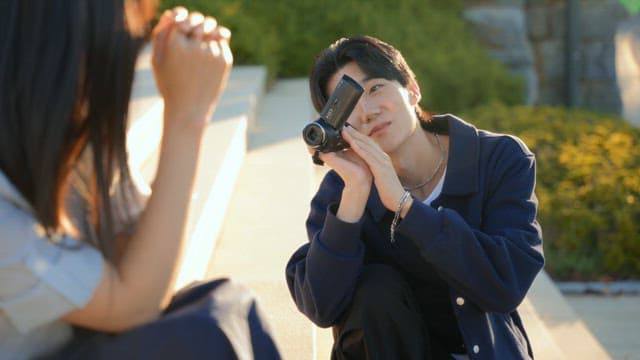 공원에서 캠코더로 영상을 찍는 커플