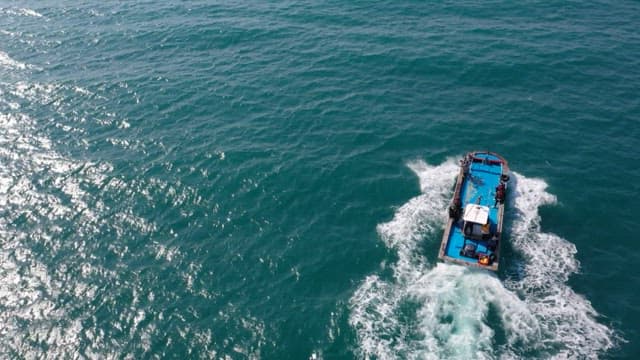 Boat sailing through the ocean on a sunny day