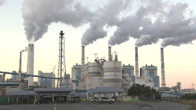 Industrial factory emitting smoke at dusk