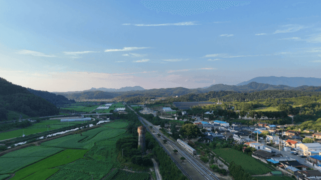 Rural village with green fields and mountains.