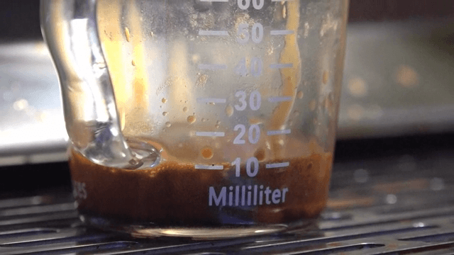 샷잔에 에스프레소가 떨어지는 장면