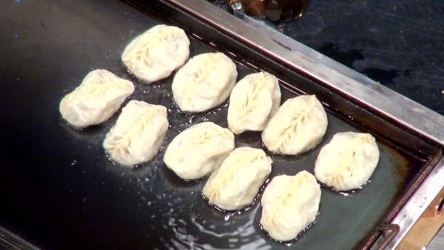 Dumplings frying on a hot griddle