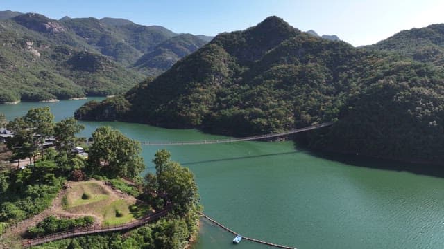 View of a Suspension Bridge with Scenic Lake and Mountain