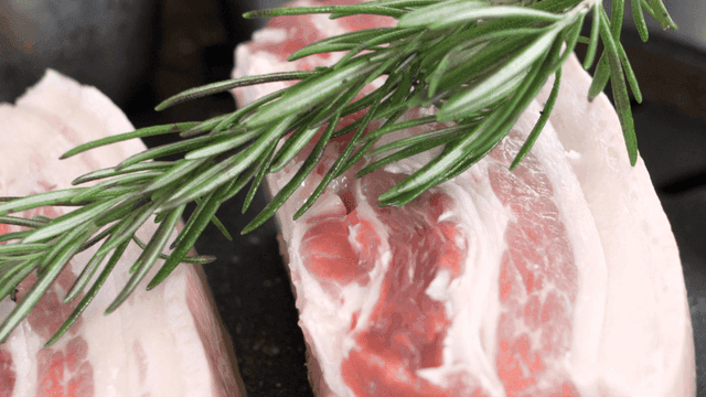 Fresh pork belly with rosemary on grill