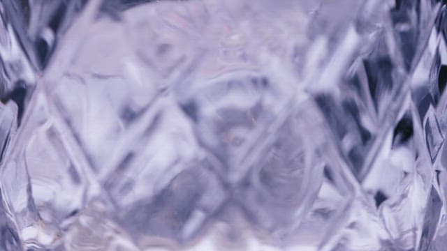 얼음이 담긴 크리스털 잔에 부어지는 음료