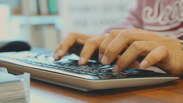 사무실에서 키보드를 치는 손