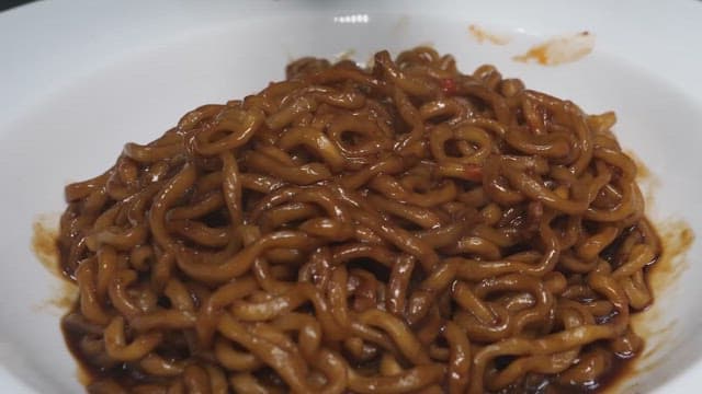 김치와 함께 먹는 흰 그릇에 담긴 짜장 라면