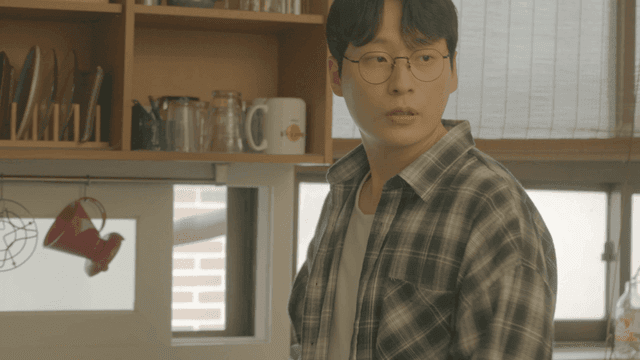 Man with glasses preparing something in kitchen
