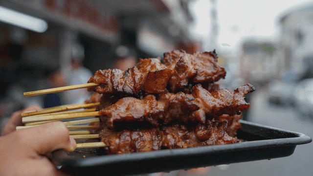 Grilled skewers on a busy street
