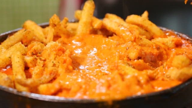 Boneless chicken dipped in fusion cream sauce with a fork